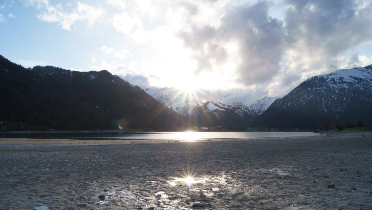 Achensee im Winter mit Eis am Ufer und verschneiten Bergen